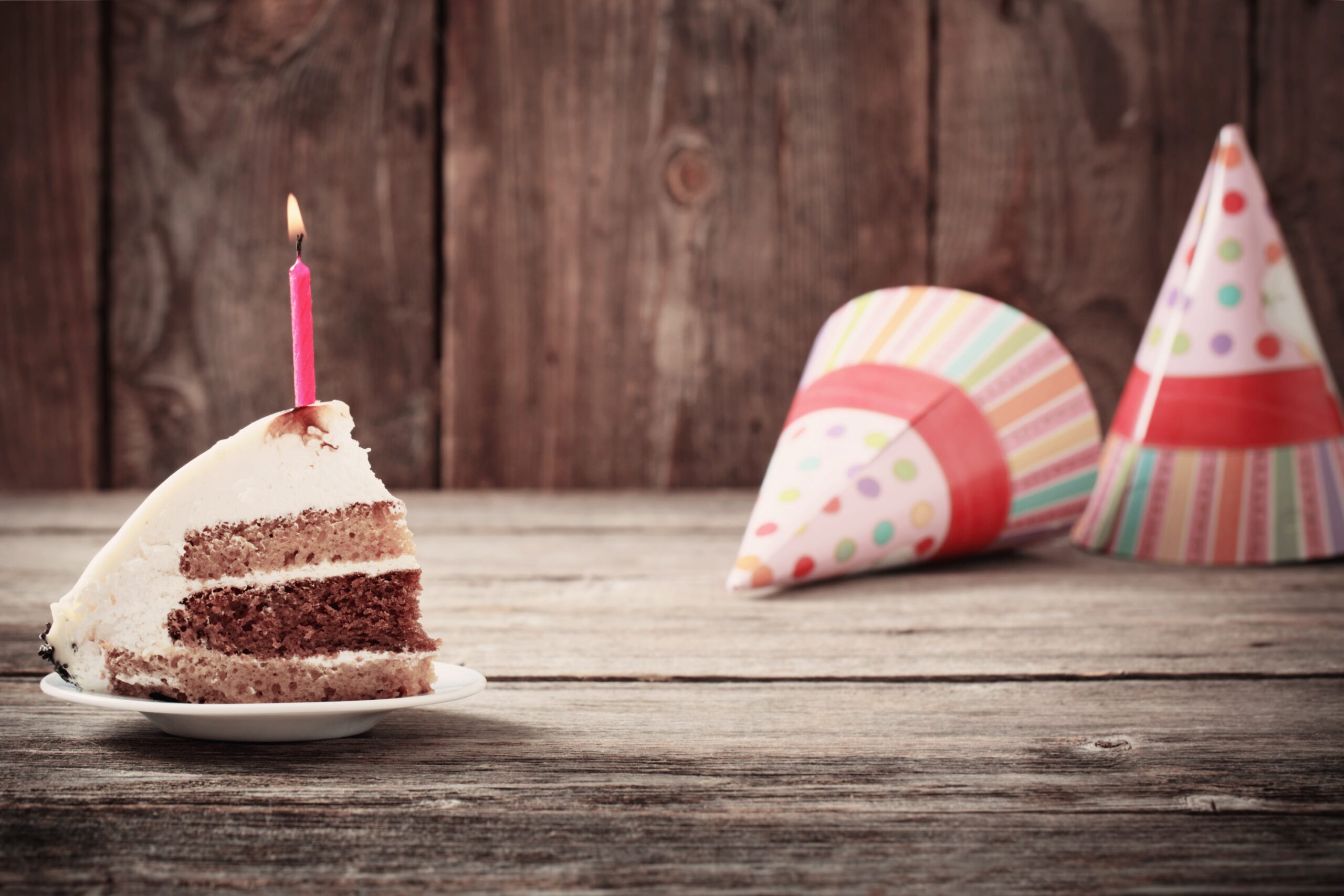birthday-cake-slice-with-burning-candle-on-table-2026-03-26-10-54-43-utc